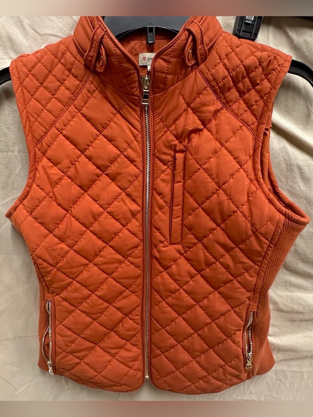 Orange puffy zip up vest jacket.